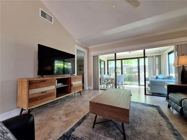 Tiled living room featuring vaulted ceiling