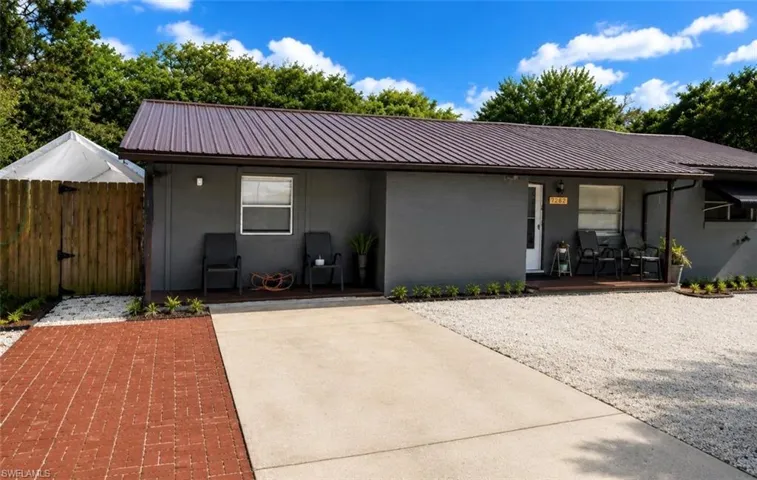 Gray exterior featuring a brown metal roof