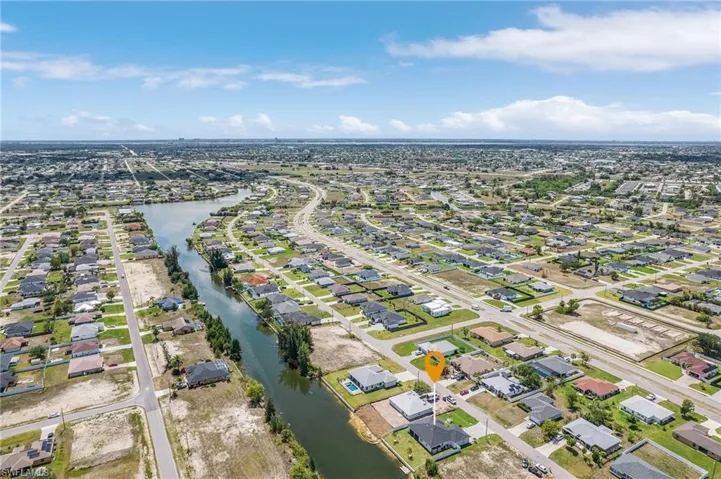 Aerial view of property and surrounding area with nearby suburban area and a large body of water