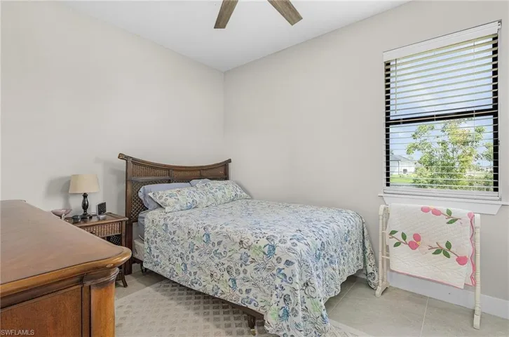 Bedroom with a ceiling fan and light tile patterned flooring