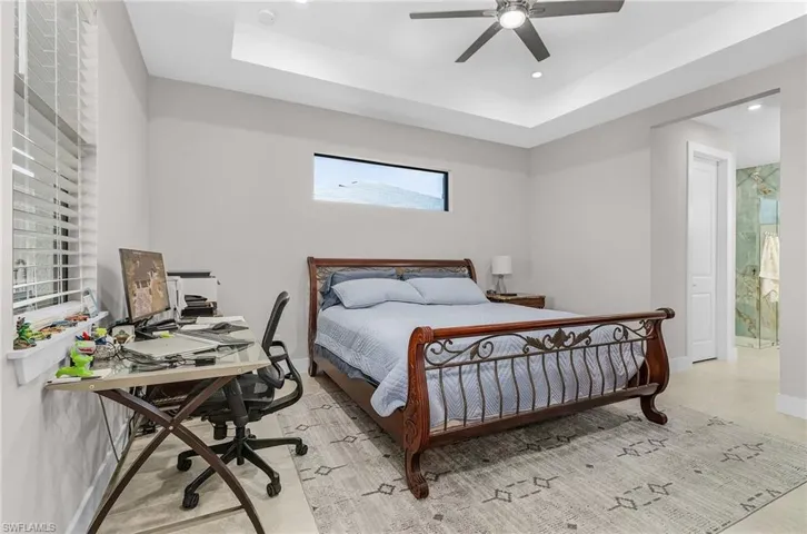 Bedroom featuring a tray ceiling, a desk, a ceiling fan, and recessed lighting