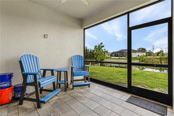 Sunroom / solarium featuring ceiling fan and a water view