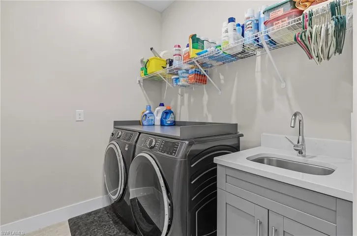 Washroom featuring separate washer and dryer and cabinet space