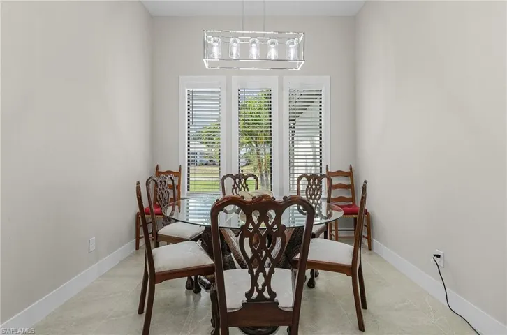 Dining space with light tile patterned flooring and a chandelier