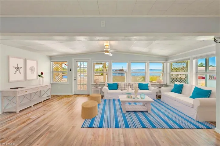 Sunroom featuring lofted ceiling and a water view