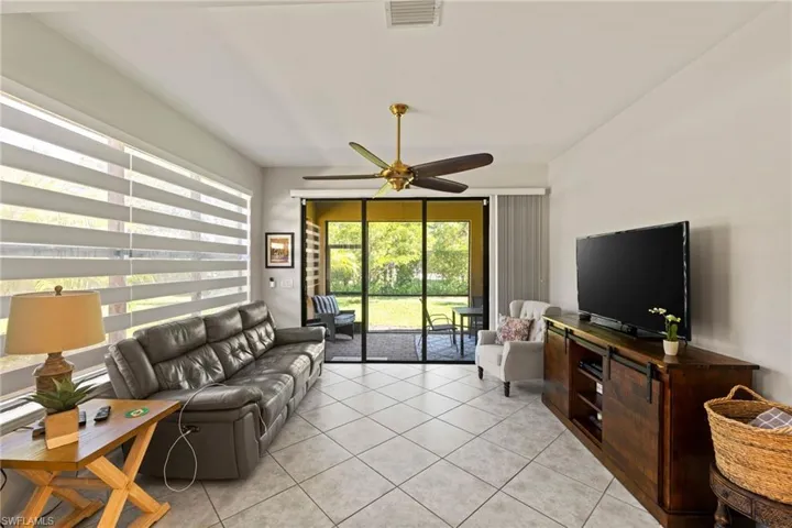 Loft/Media sunroom with light tile flooring and ceiling fan