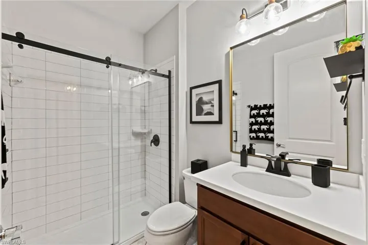 Guest Bathroom with shower door, vanity, and toilet