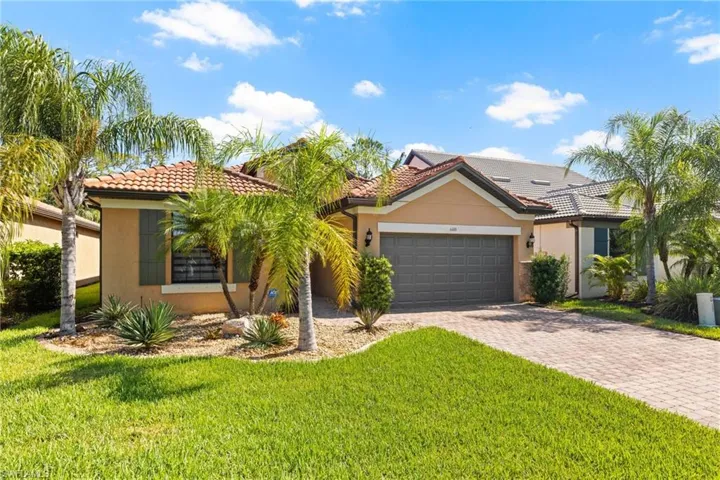 View of front of house featuring a garage and a front lawn