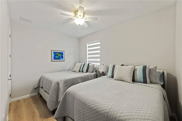 Guest Bedroom with hardwood / wood-style flooring and ceiling fan