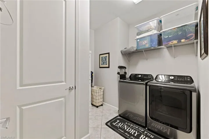 Laundry room featuring independent washer and dryer and light tile floors