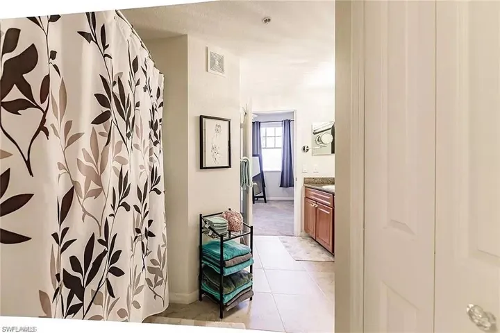 Full bathroom featuring vanity, tile patterned floors, and a shower with curtain