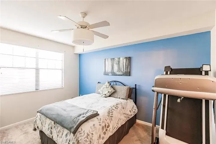 Carpeted bedroom featuring baseboards and ceiling fan