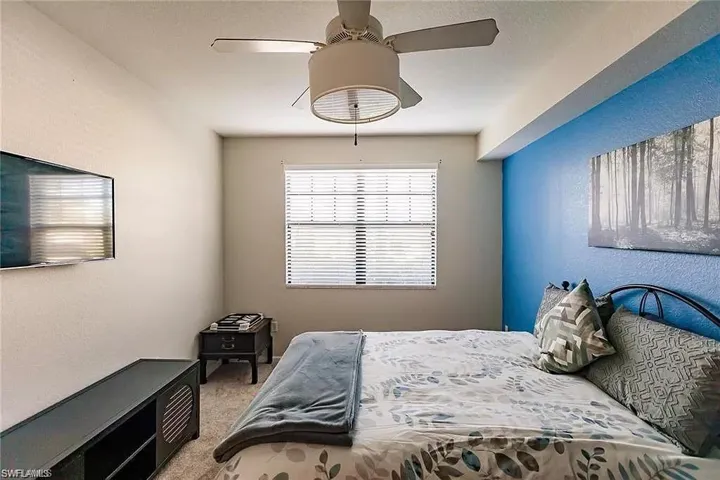 Carpeted bedroom featuring a ceiling fan