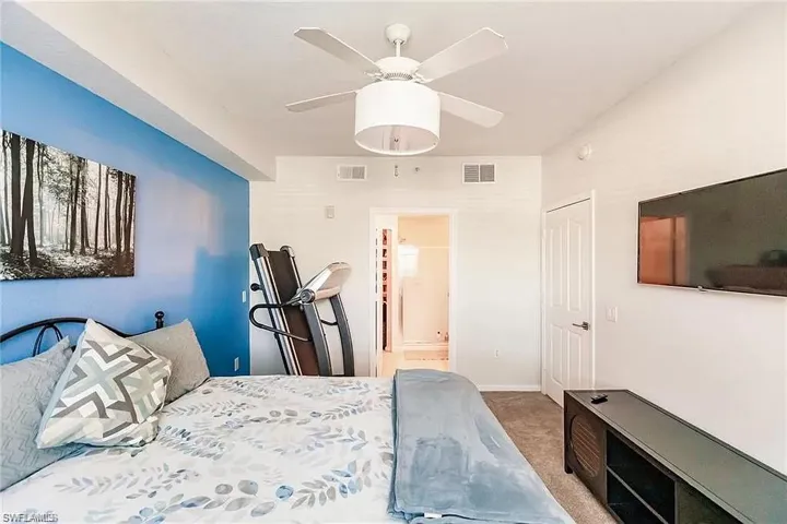 Bedroom featuring carpet flooring, a ceiling fan, and ensuite bathroom