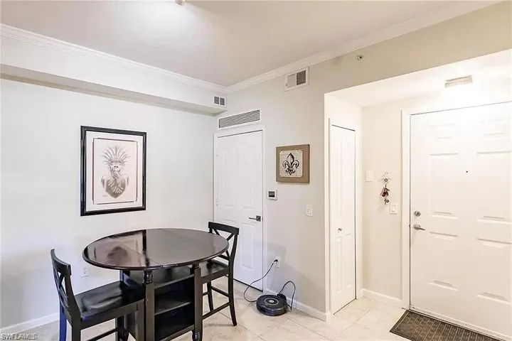 Dining area with crown molding and light tile patterned flooring