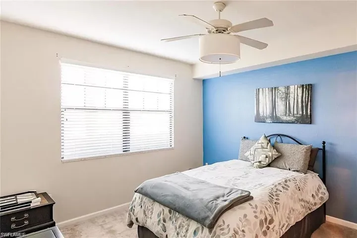 Carpeted bedroom featuring baseboards and a ceiling fan