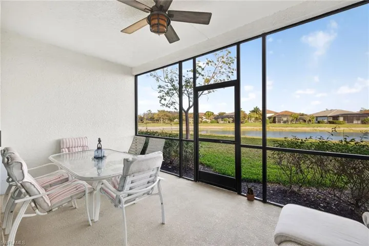 Sunroom / solarium with outdoor dining area, a ceiling fan, and a water view