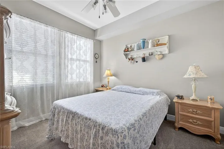 Carpeted bedroom with ceiling fan and baseboards