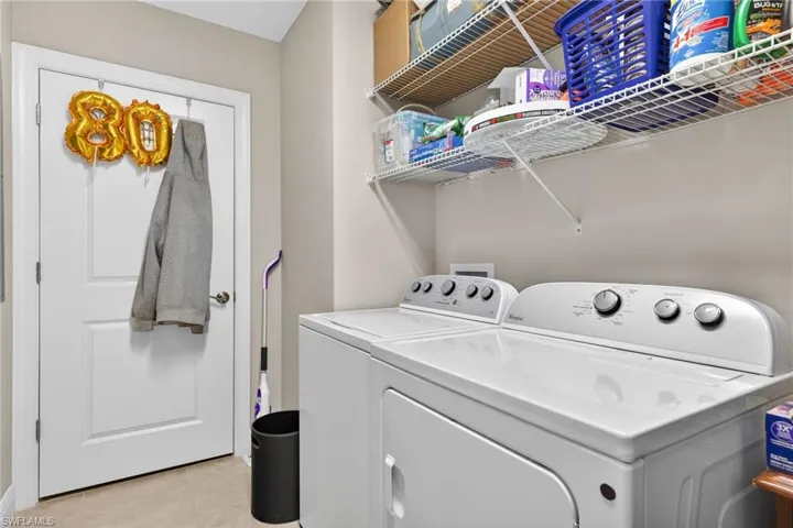 Laundry room featuring independent washer and dryer and light tile patterned flooring