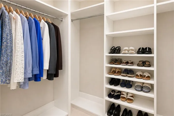 Built-in closet system featuring multiple hanging rods and integrated shelving