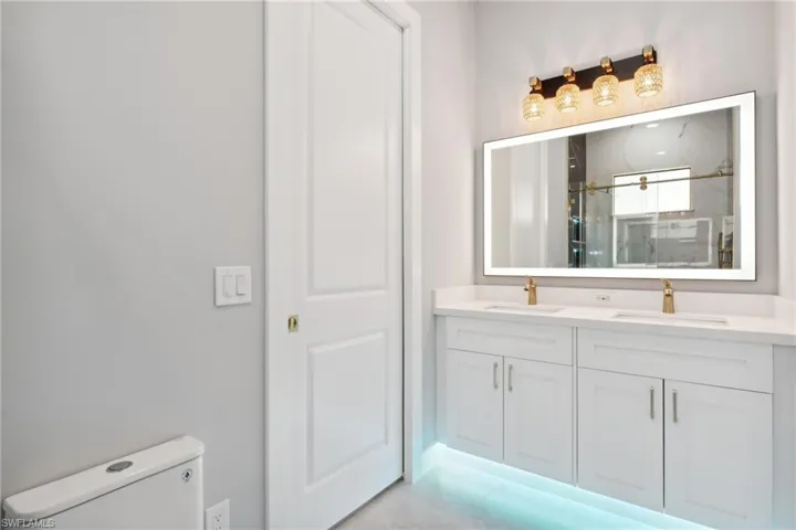 Bathroom with toilet, vanity, and walk in shower