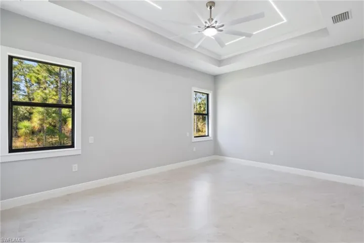 Spare room with a tray ceiling and ceiling fan