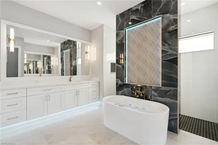 Bathroom with vanity, tile walls, and independent shower and bath