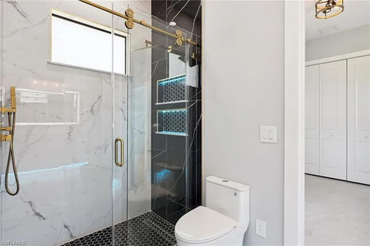 Bathroom featuring toilet and a shower with door