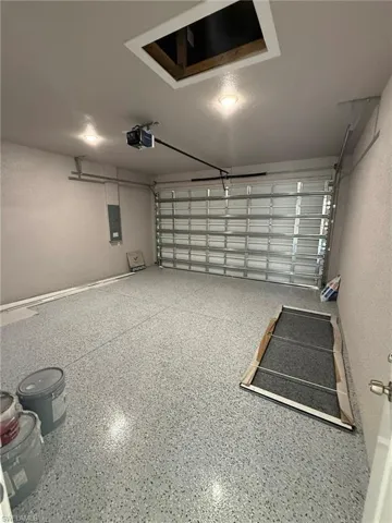 Garage with electric panel and a garage door opener