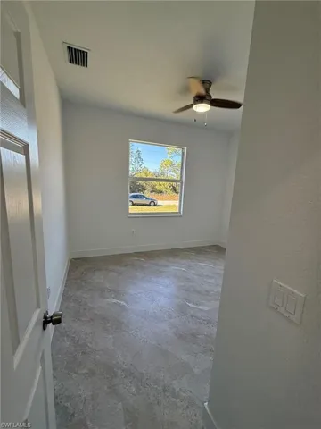 Empty room featuring baseboards and ceiling fan