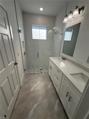 Bathroom featuring double vanity and a stall shower