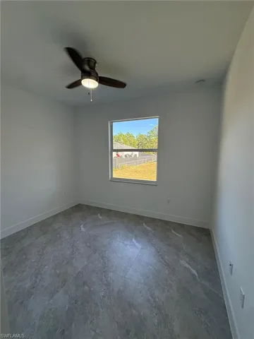 Empty room with baseboards and ceiling fan