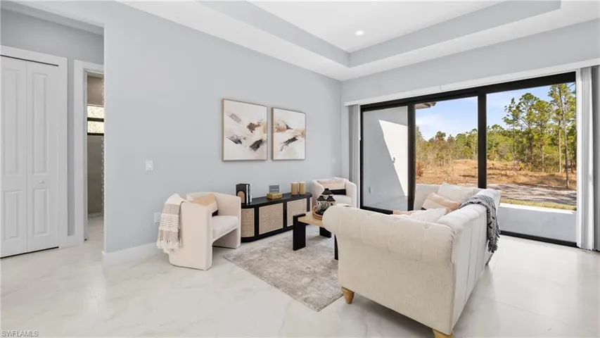 Living area with a raised ceiling and baseboards