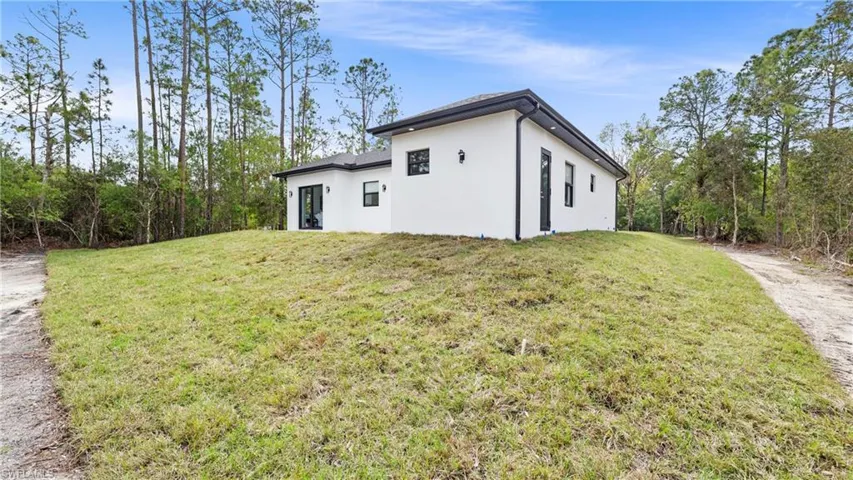 View of side of home featuring a yard and stucco siding