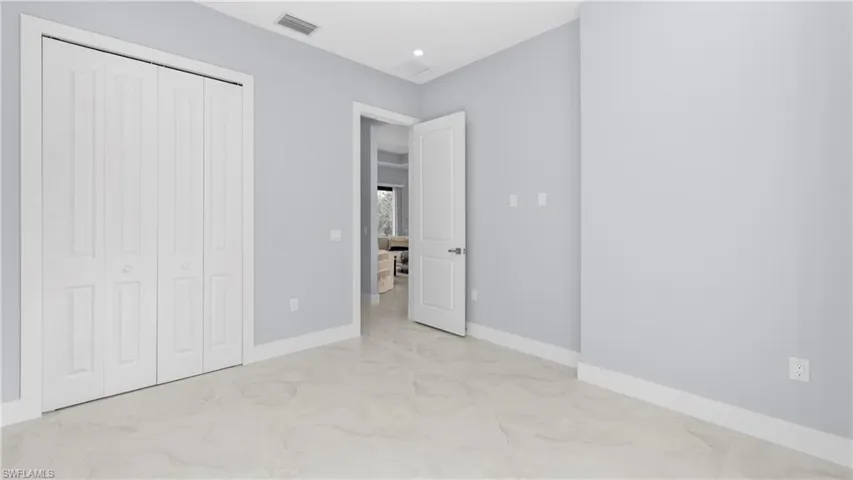 Unfurnished bedroom with light marble finish flooring, a closet, and recessed lighting