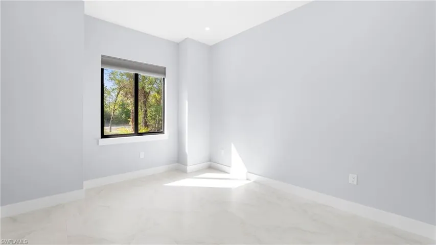 Empty room featuring light marble finish floors and baseboards