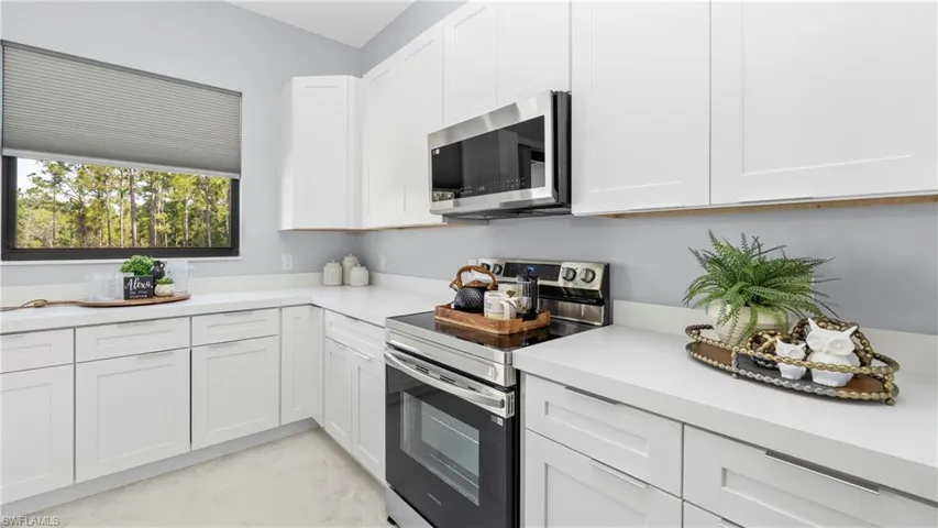 Kitchen featuring stainless steel appliances and white cabinetry