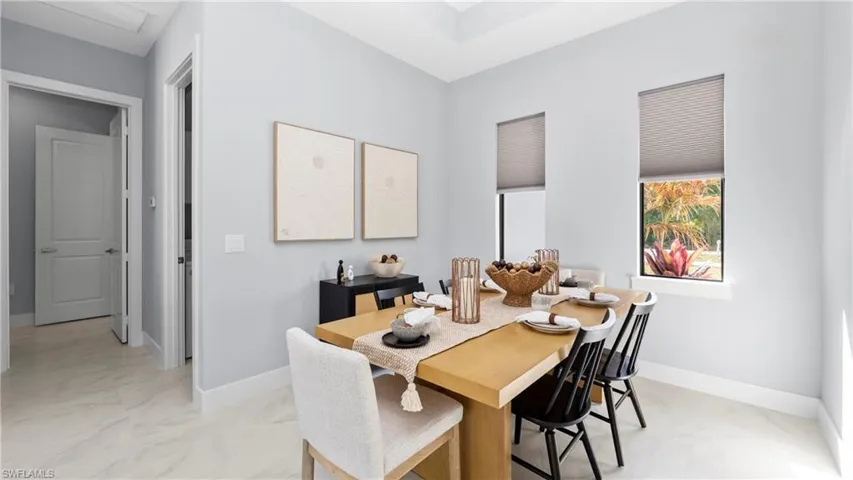 Dining area with baseboards and light marble finish floors