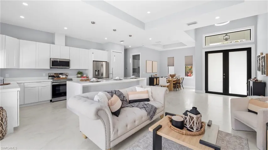 Living area featuring french doors, recessed lighting, and a high tray ceiling