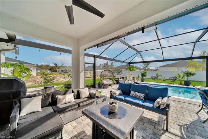 View of patio / terrace featuring an outdoor hangout area, glass enclosure, and a ceiling fan