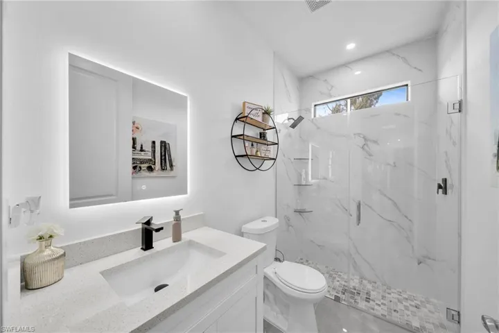 Full bath with a marble finish shower and vanity