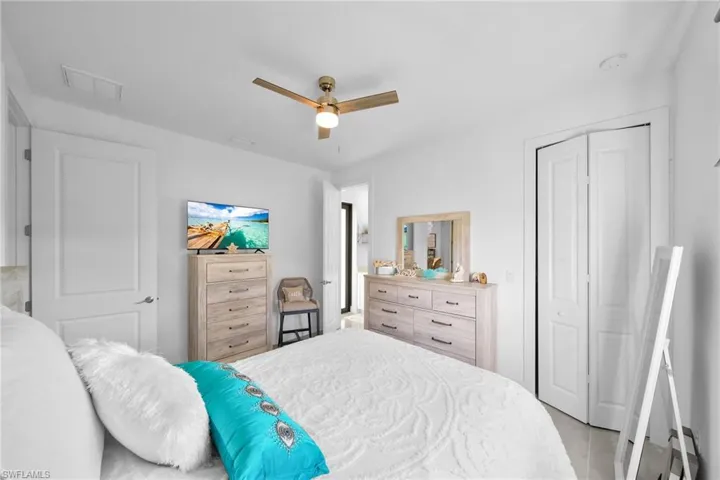 Bedroom with a ceiling fan, a closet, and light tile patterned floors