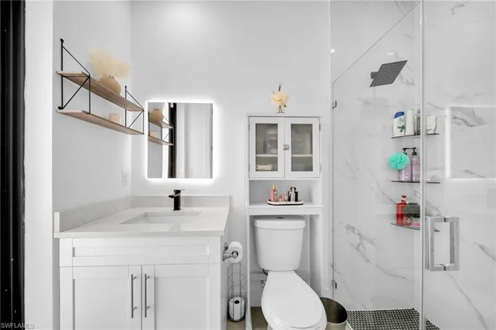 Full bathroom with a marble finish shower and vanity