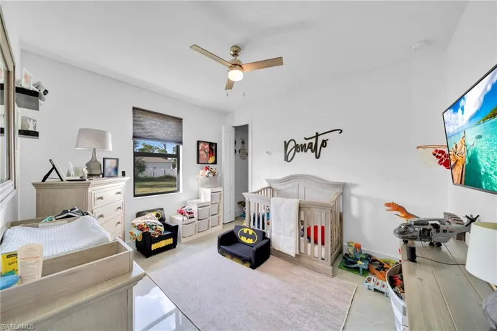 Tiled bedroom with a ceiling fan