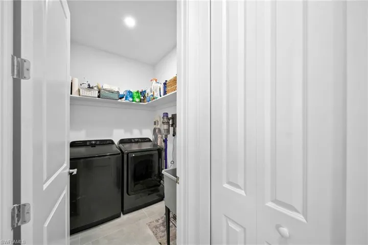 Laundry area featuring washing machine and dryer and light tile patterned flooring