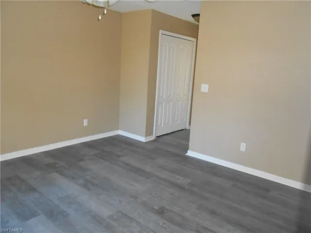 Spare room featuring dark wood-style floors