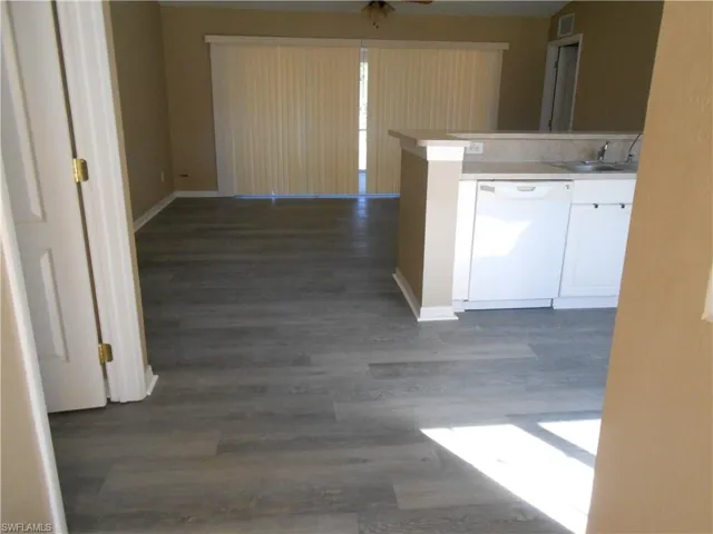 Hallway with dark wood finished floors and a sink