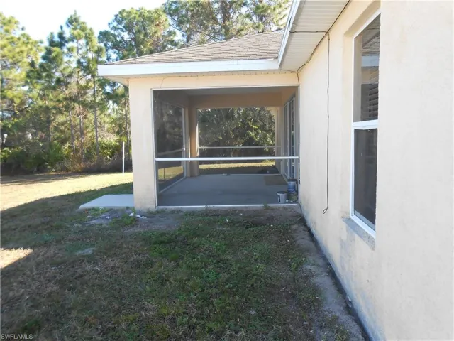 View of green lawn featuring a sunroom