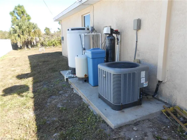 Exterior view of stucco siding and a water softener system