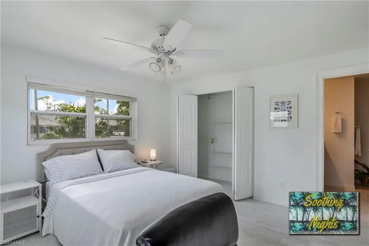 Bedroom with light wood finished floors, ceiling fan, and a closet